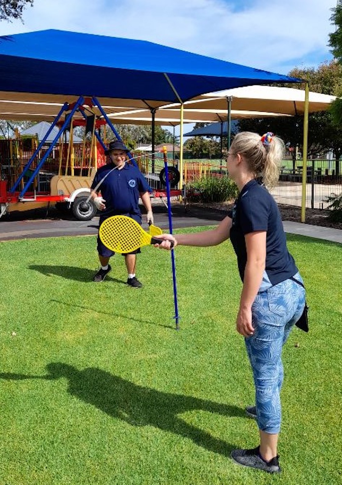 Image description: A male student who is Deaf plays totem tennis with a Student Support Officer (SSO). 